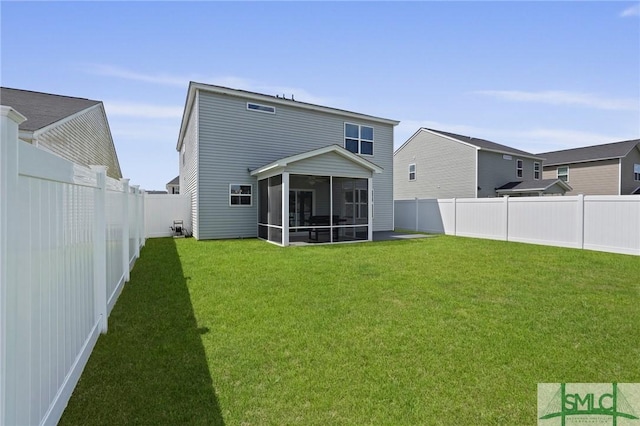 back of house featuring a lawn, a fenced backyard, and a sunroom