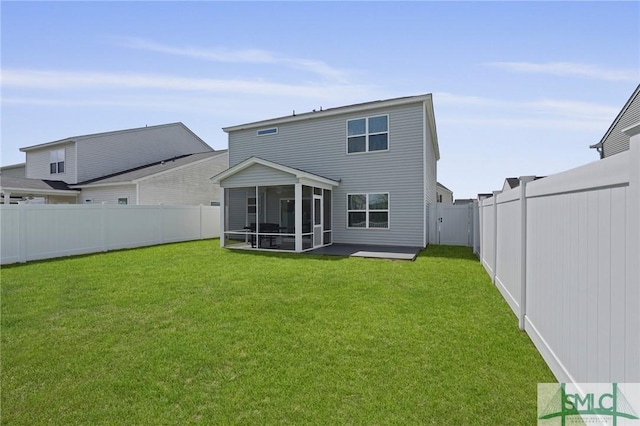 rear view of property with a fenced backyard, a sunroom, and a yard