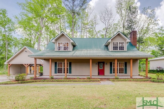 farmhouse inspired home featuring metal roof, a chimney, a front lawn, and a porch