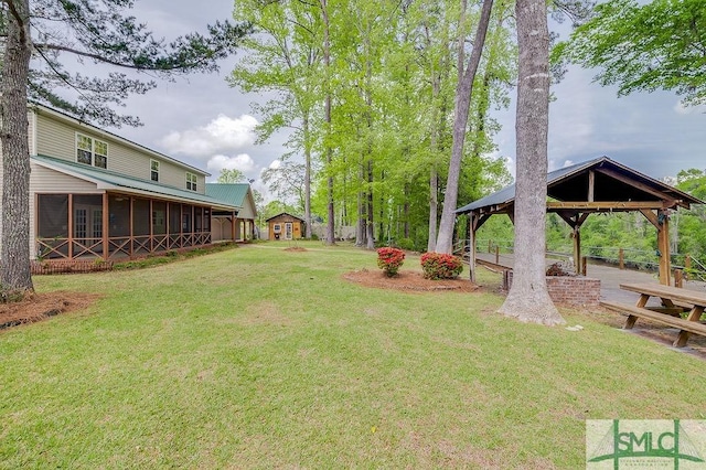 view of yard featuring a sunroom and a gazebo