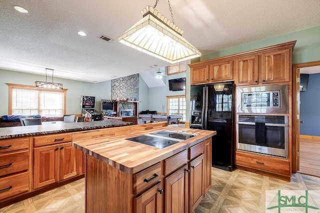 kitchen with wood counters, visible vents, black appliances, and a healthy amount of sunlight