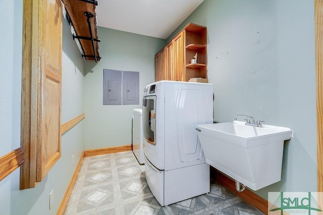 laundry room with electric panel, baseboards, a sink, cabinet space, and light floors