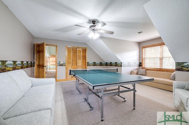 recreation room with a ceiling fan, a textured ceiling, light colored carpet, and visible vents