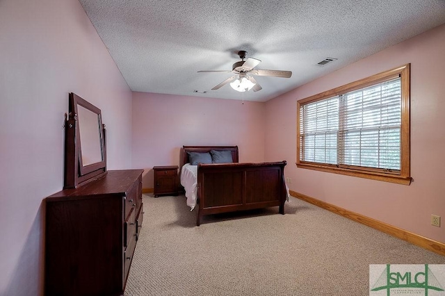 bedroom with light carpet, a textured ceiling, baseboards, and visible vents