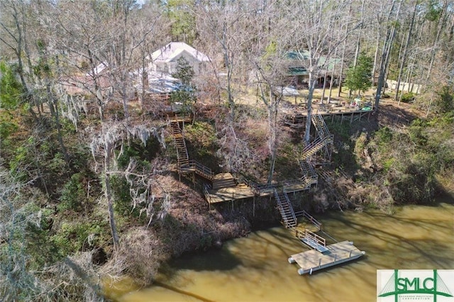 birds eye view of property featuring a water view and a view of trees