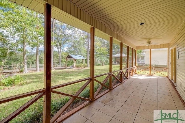 unfurnished sunroom with ceiling fan