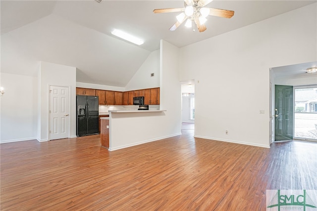 28 Raven Wood Way, Pooler, GA 31322 - unfurnished living room featuring high vaulted ceiling, light wood finished floors, baseboards, and ceiling fan with notable chandelier