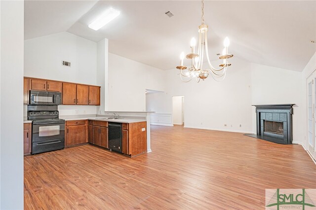 28 Raven Wood Way, Pooler, GA 31322 - kitchen with brown cabinetry, black appliances, light countertops, open floor plan, and a notable chandelier