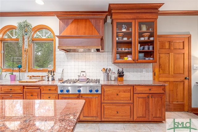 57 Delegal Rd, Savannah, GA 31411 - kitchen with stainless steel gas cooktop, brown cabinets, custom range hood, and glass insert cabinets