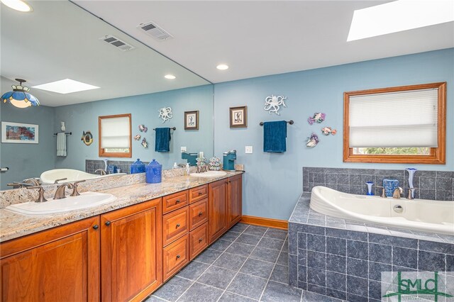 57 Delegal Rd, Savannah, GA 31411 - full bathroom featuring a skylight, tiled tub, a sink, and visible vents