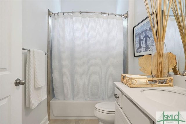 bathroom featuring toilet, shower / bath combo with shower curtain, and vanity