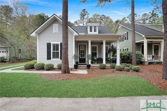 bungalow-style house with a shingled roof, covered porch, and a front yard