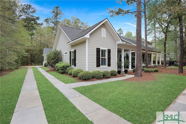 view of front of home with a front lawn and roof with shingles
