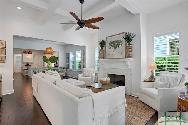 living area with coffered ceiling, ceiling fan, baseboards, and dark wood finished floors
