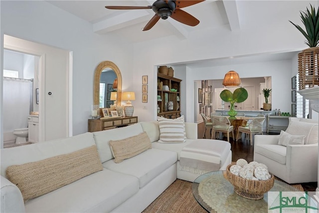 living room featuring ceiling fan, beam ceiling, and plenty of natural light