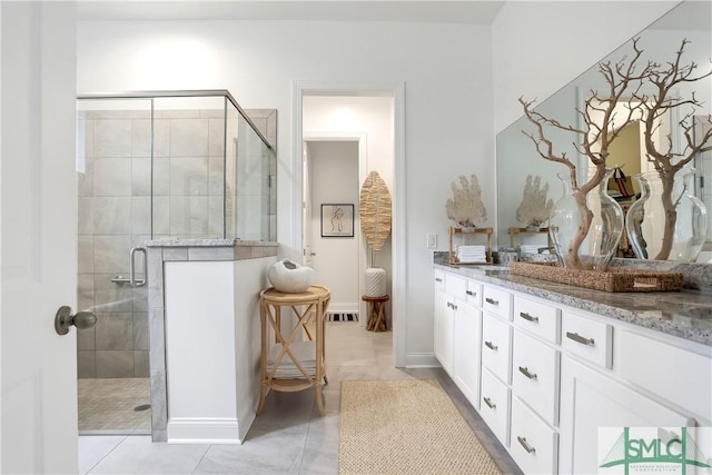 bathroom featuring vanity, baseboards, a stall shower, tile patterned floors, and visible vents