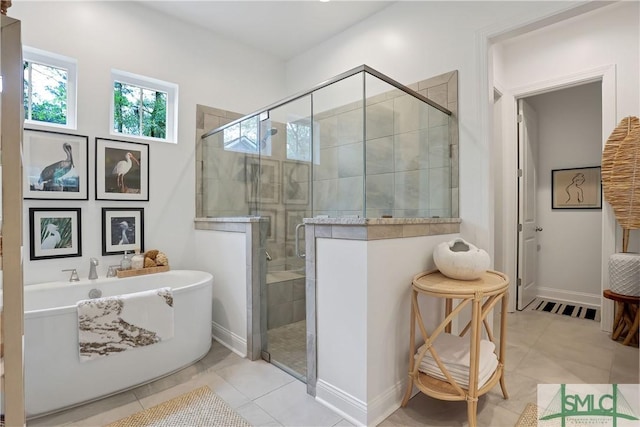 full bathroom featuring a stall shower, a healthy amount of sunlight, tile patterned flooring, and a soaking tub