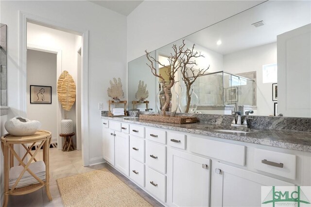 bathroom featuring a shower stall, double vanity, visible vents, and a sink