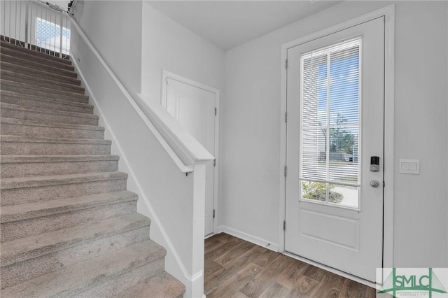 entrance foyer with stairs, baseboards, and wood finished floors