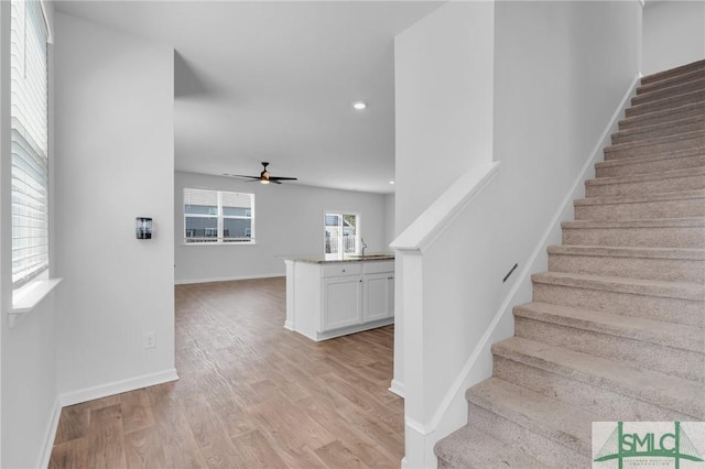 staircase with recessed lighting, ceiling fan, baseboards, and wood finished floors