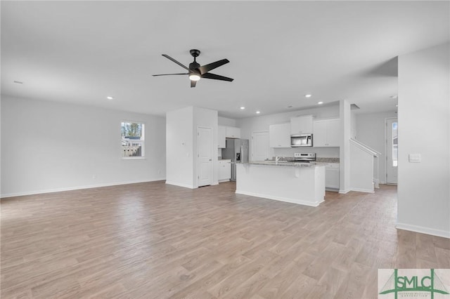 unfurnished living room featuring recessed lighting, light wood finished floors, baseboards, and ceiling fan