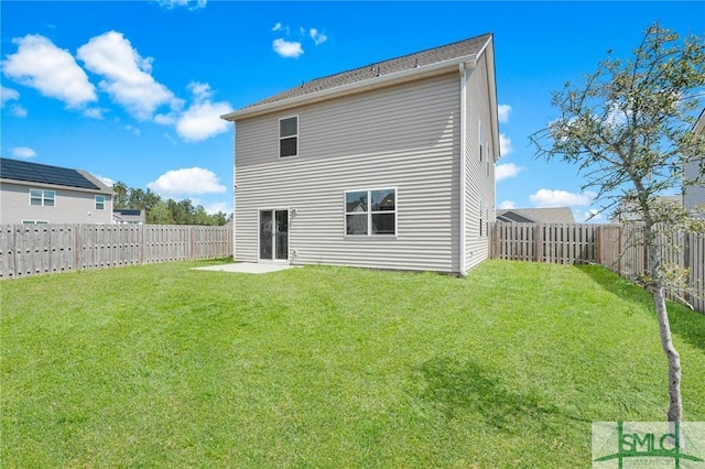 rear view of property with a yard and a fenced backyard