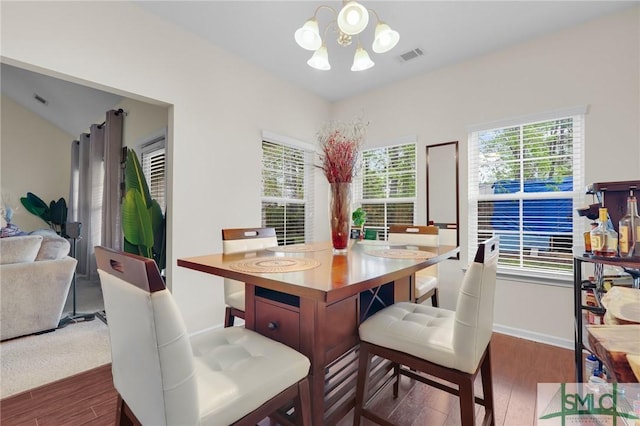 dining room with dark wood-type flooring, baseboards, a notable chandelier, and visible vents