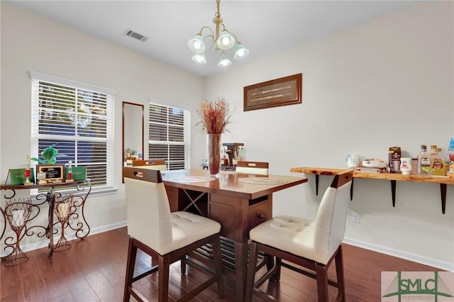 dining room with a chandelier, dark wood-type flooring, baseboards, and visible vents