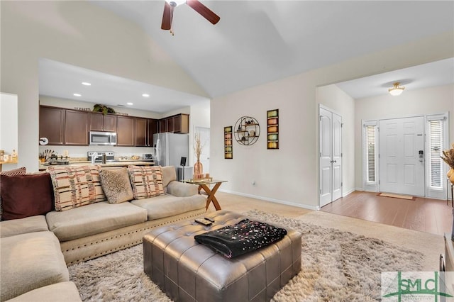 living area featuring baseboards, ceiling fan, light wood-style floors, recessed lighting, and high vaulted ceiling