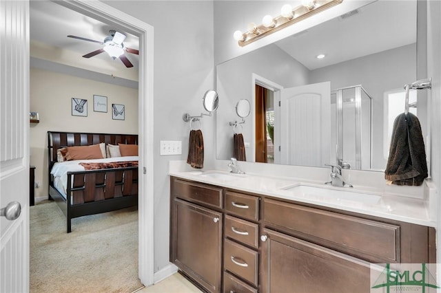 bathroom featuring double vanity, a stall shower, visible vents, ceiling fan, and a sink