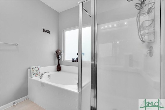 full bath with baseboards, a stall shower, and a garden tub