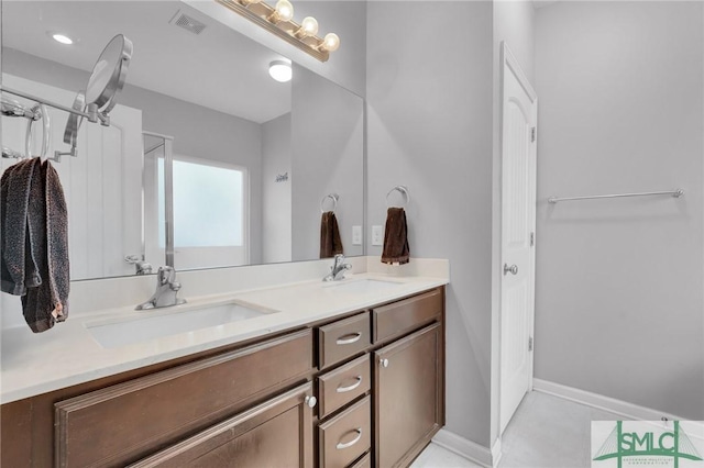 bathroom featuring a sink, visible vents, baseboards, and double vanity