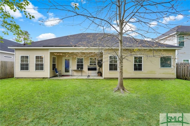 back of house featuring fence, a patio, and a lawn