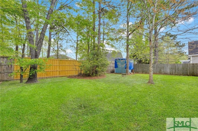 view of yard featuring a fenced backyard, a storage shed, and an outbuilding