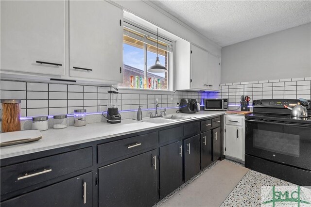 109 Seminole St, Savannah, GA 31406 - kitchen with a sink, a textured ceiling, black / electric stove, stainless steel microwave, and white cabinetry