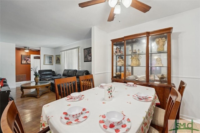 dining area featuring baseboards, a ceiling fan, and wood finished floors