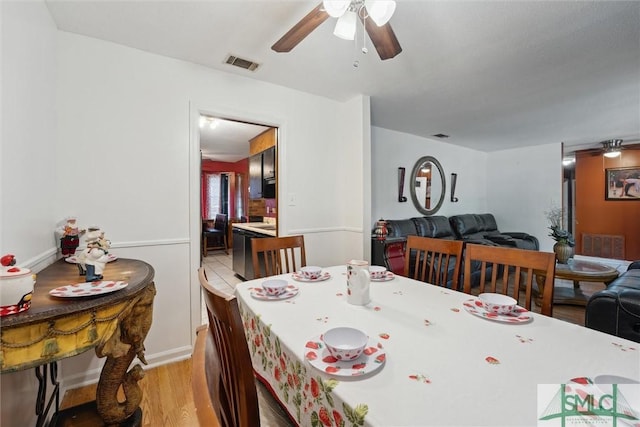 dining space with visible vents, light wood-style flooring, and ceiling fan
