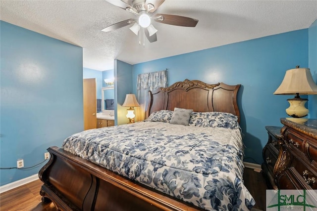 bedroom featuring baseboards, ensuite bath, a textured ceiling, ceiling fan, and wood finished floors