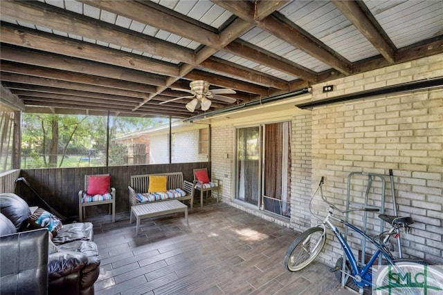 sunroom / solarium featuring beamed ceiling and a ceiling fan
