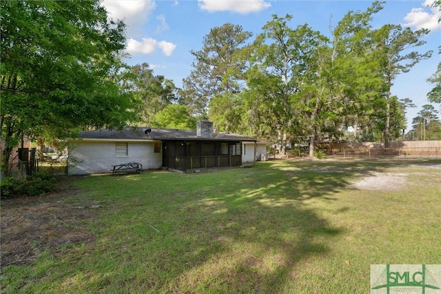 view of yard featuring fence and a sunroom