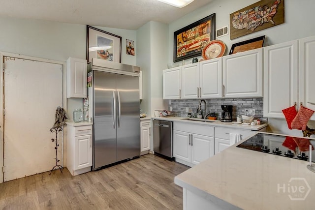 130 N Leeds Gate Rd, Savannah, GA 31406 - kitchen with appliances with stainless steel finishes, backsplash, white cabinets, and light wood-style flooring