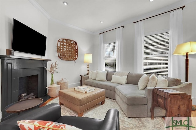 living area with a fireplace, baseboards, ornamental molding, recessed lighting, and wood finished floors