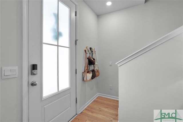doorway featuring baseboards and light wood-type flooring
