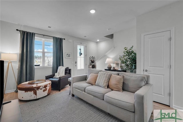 living area featuring light wood-style floors, baseboards, visible vents, and recessed lighting