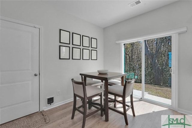 dining space with light wood-style floors, visible vents, and baseboards