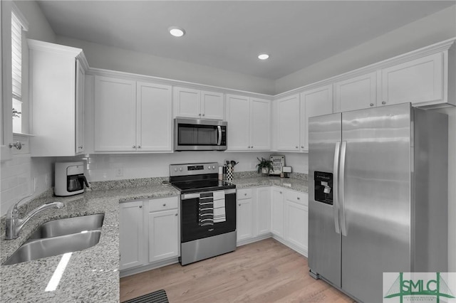 kitchen featuring a sink, appliances with stainless steel finishes, and white cabinetry