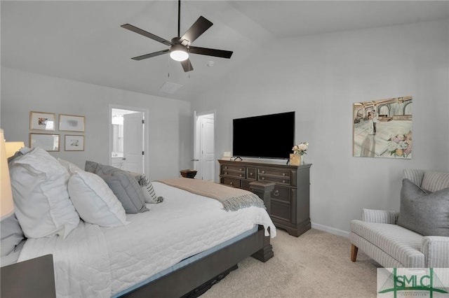 bedroom featuring ceiling fan, ensuite bathroom, vaulted ceiling, light carpet, and baseboards
