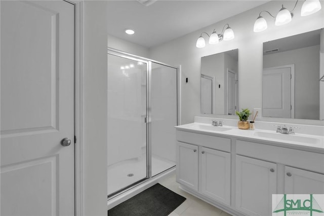 full bath featuring a sink, tile patterned flooring, double vanity, and a stall shower