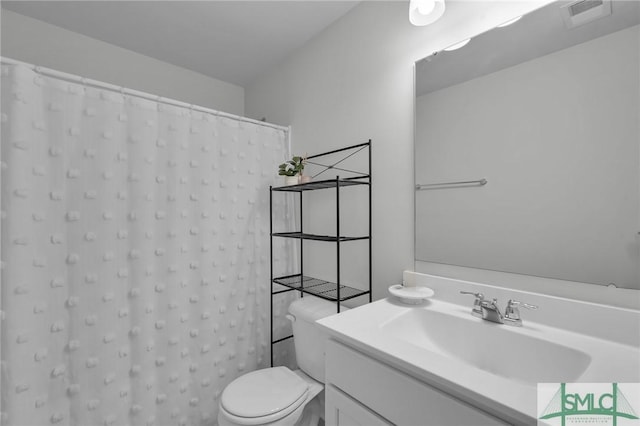 bathroom featuring toilet, vanity, visible vents, and a shower with curtain