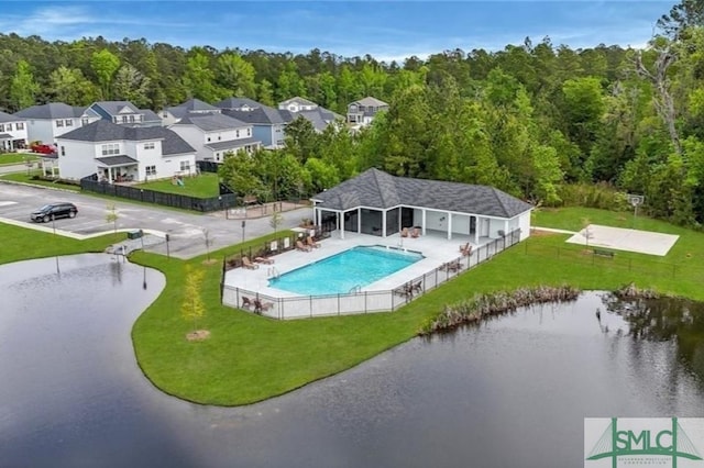 view of swimming pool with a fenced in pool, a patio, a forest view, fence, and a lawn